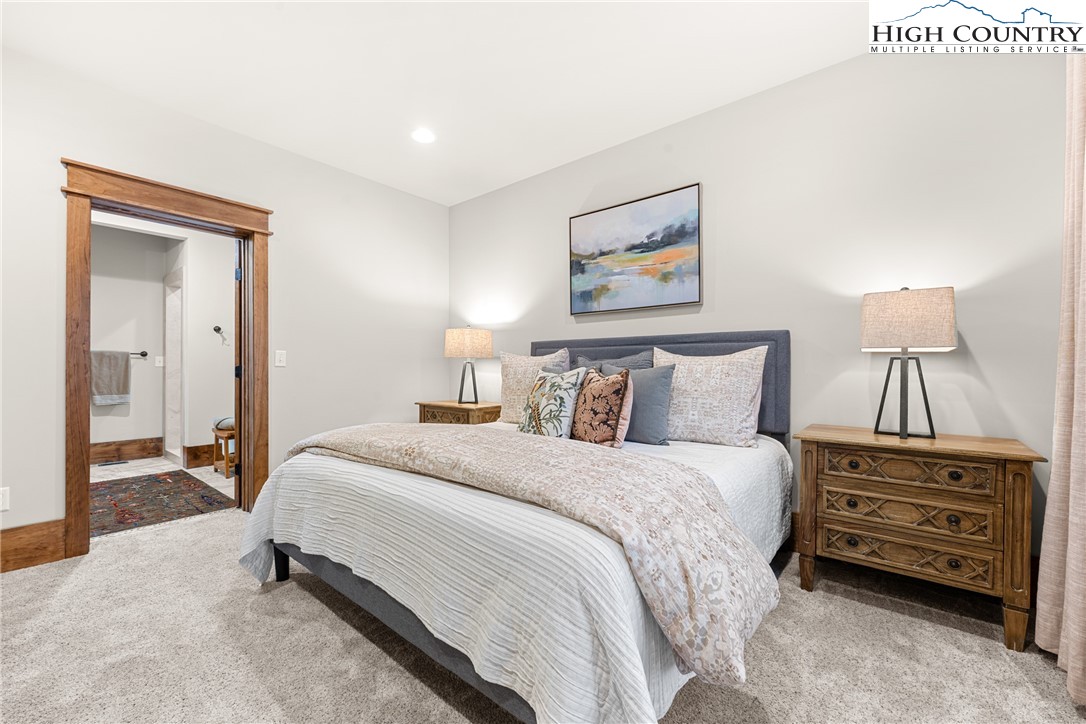 299 Edgewood Path Blowing Rock, NC 28605 - Photo 22 of 39 a bedroom with a bed a lamp and a dresser
