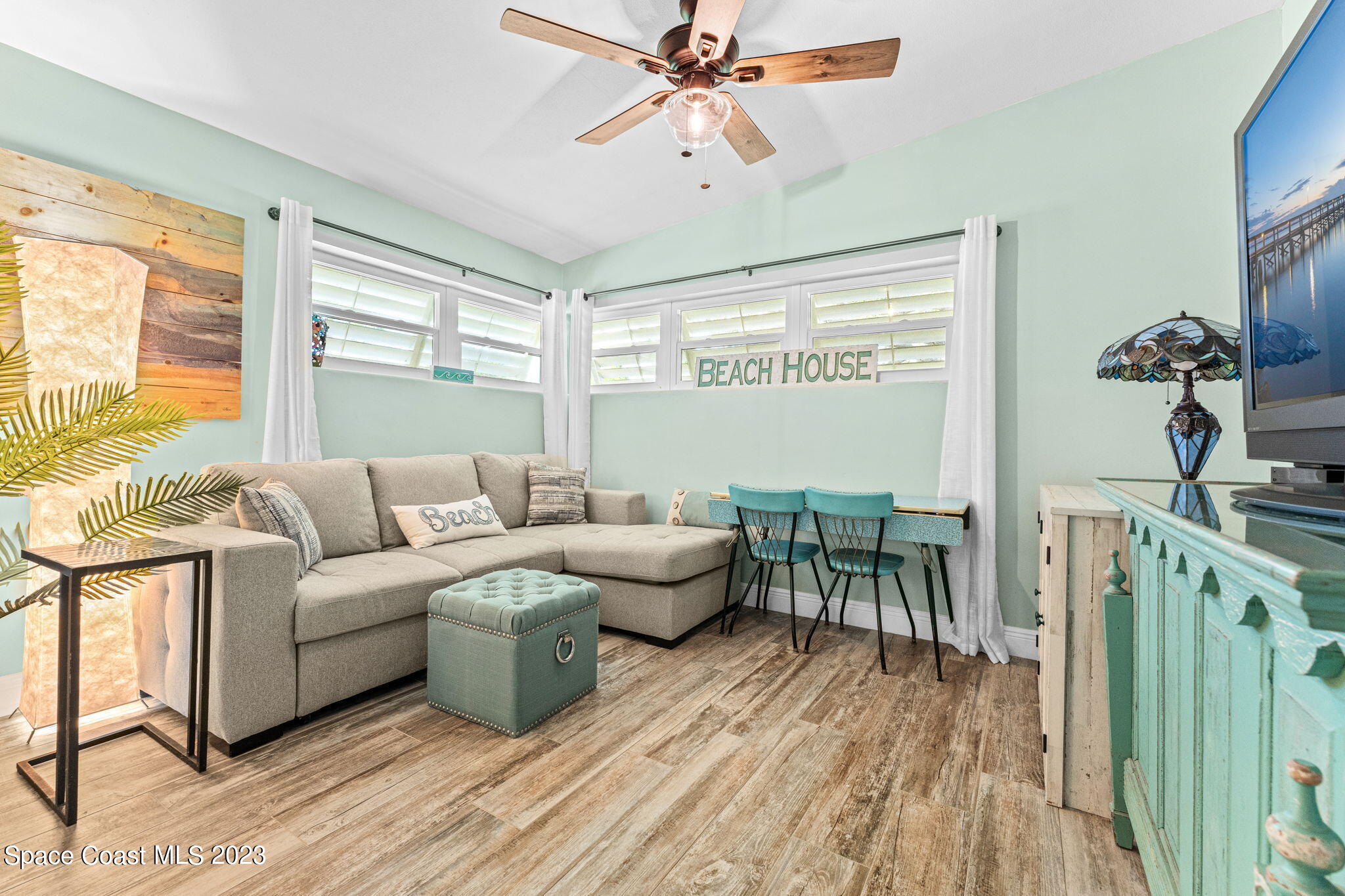 2230 Reef Avenue Indialantic, FL 32903 - Photo 14 of 31 a living room with furniture a large window and wooden floor
