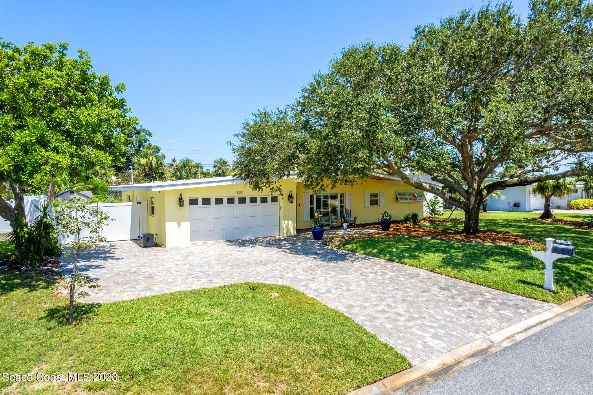 2230 Reef Avenue Indialantic, FL 32903 - Photo 31 of 31 a front view of a house with a garden and tree