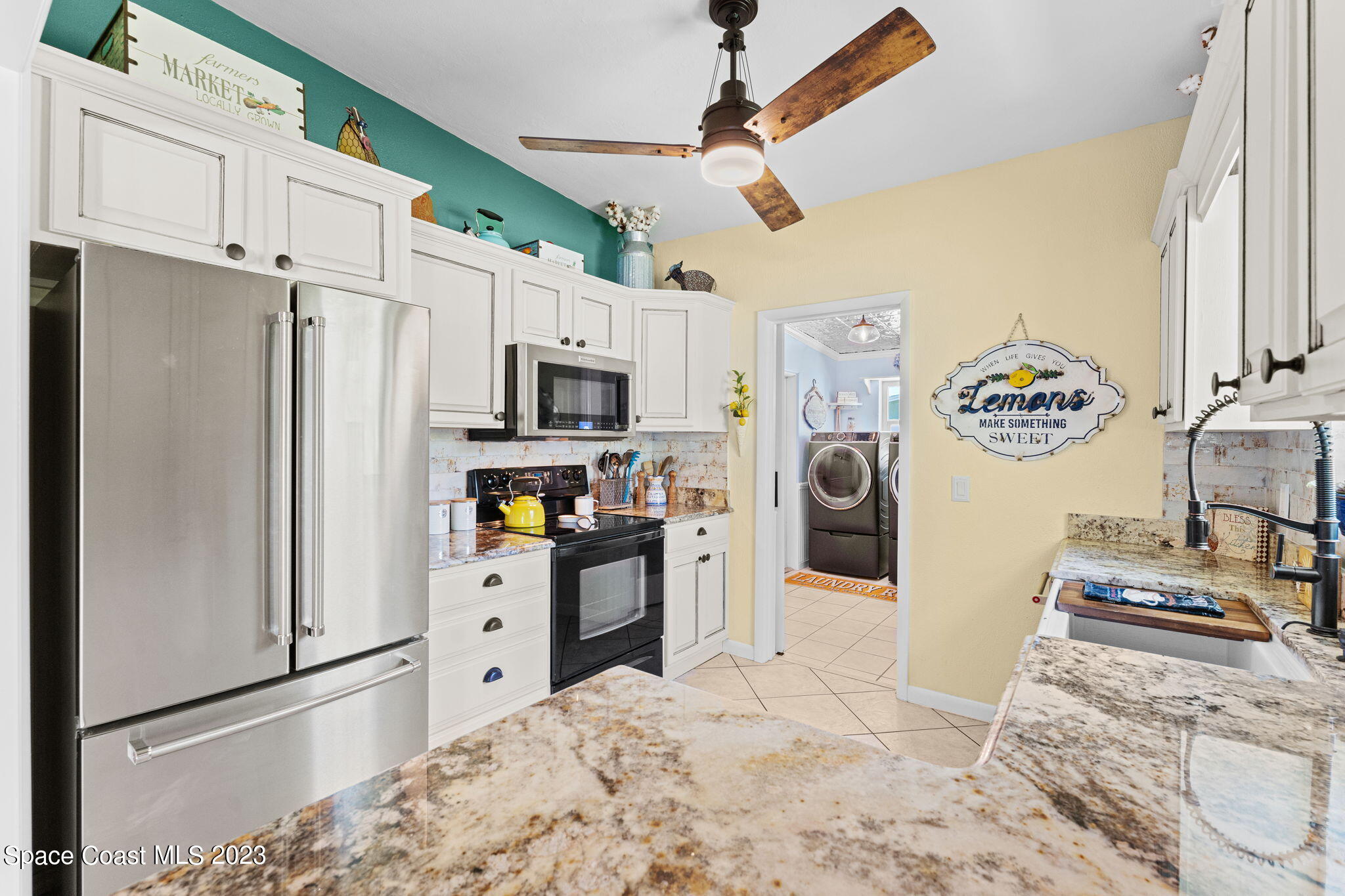 2230 Reef Avenue Indialantic, FL 32903 - Photo 7 of 31 a kitchen with stainless steel appliances a refrigerator sink and microwave