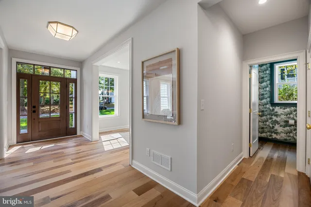 a view of a a dining room and livingroom with furniture wooden floor a chandelier