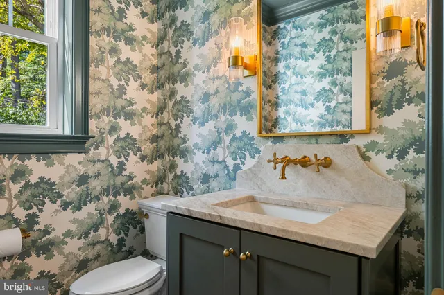 a kitchen with a stove a chandelier and wooden floor