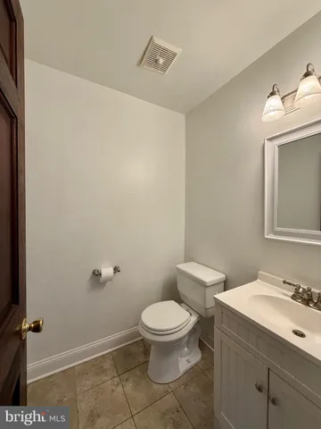 a bathroom with a granite countertop sink a toilet and a mirror