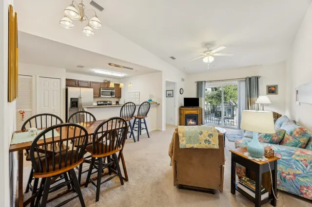 a living room with furniture a dining table and paintings on the wall