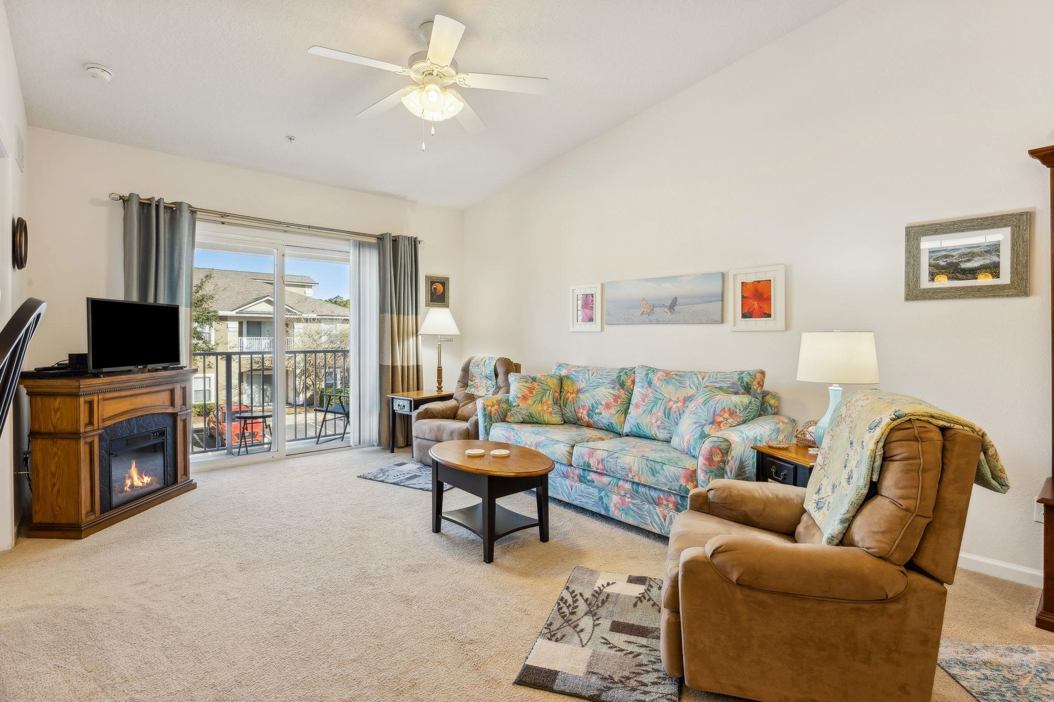 2861 Golden Lake Loop St. Augustine, FL 32084 - Photo 15 of 40 Living room with light colored carpet, a glass covered fireplace, lofted ceiling, and a ceiling fan