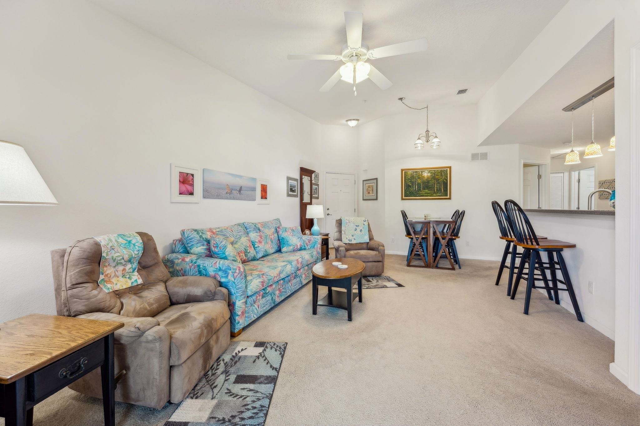 2861 Golden Lake Loop St. Augustine, FL 32084 - Photo 17 of 40 Living area featuring light carpet, high vaulted ceiling, a ceiling fan, and a chandelier