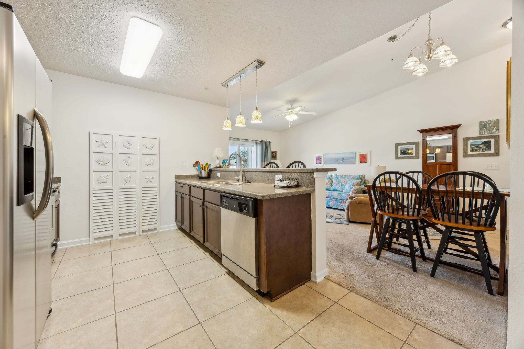 2861 Golden Lake Loop St. Augustine, FL 32084 - Photo 7 of 40 Kitchen with a peninsula, decorative light fixtures, stainless steel appliances, light colored carpet, and a textured ceiling