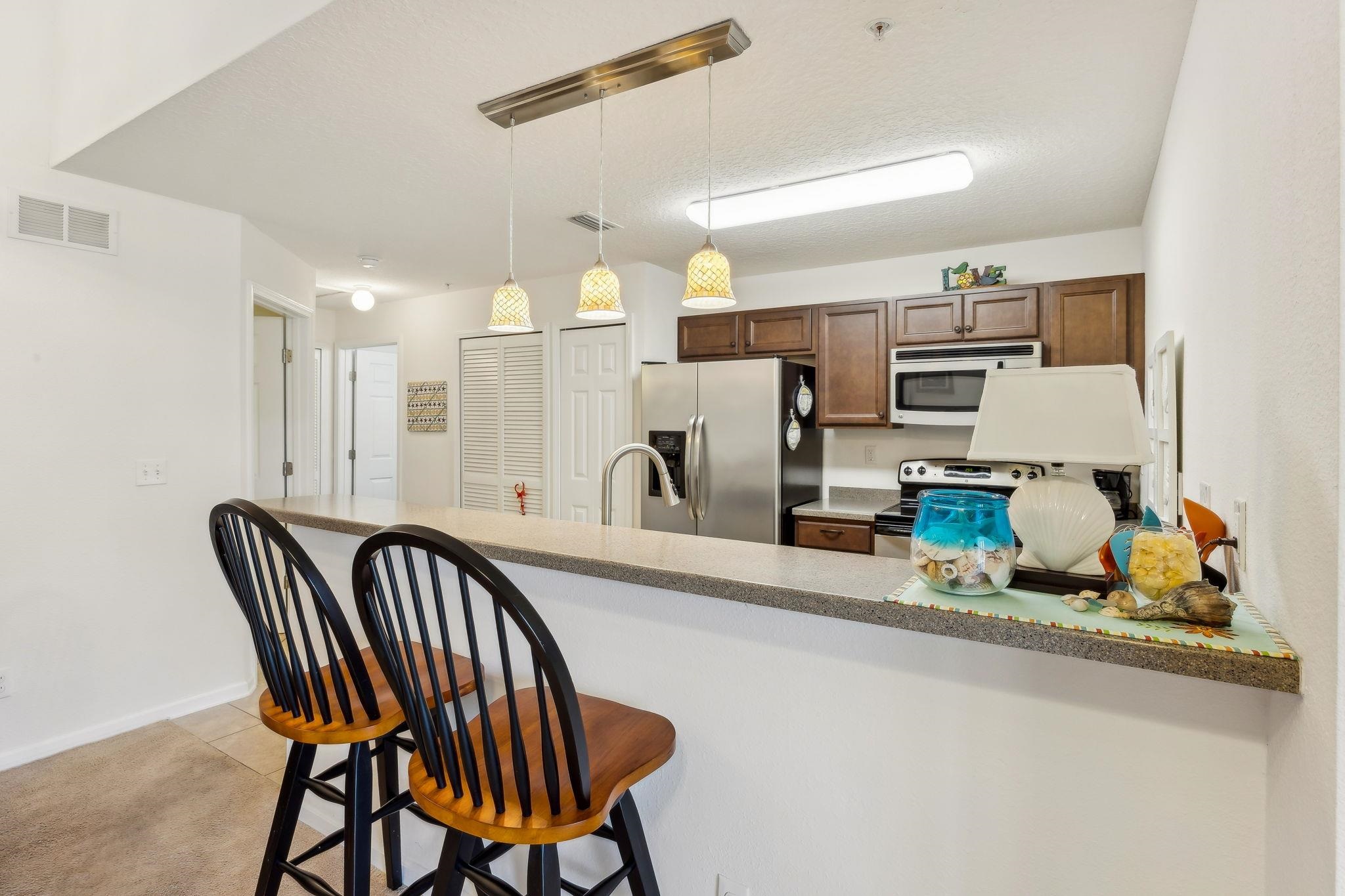 2861 Golden Lake Loop St. Augustine, FL 32084 - Photo 9 of 40 Kitchen featuring a breakfast bar area, stainless steel appliances, hanging light fixtures, a peninsula, and light tile patterned flooring