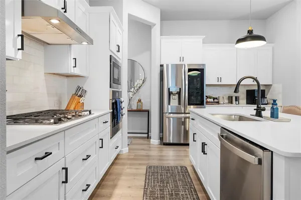 a kitchen with stainless steel appliances a sink stove and refrigerator