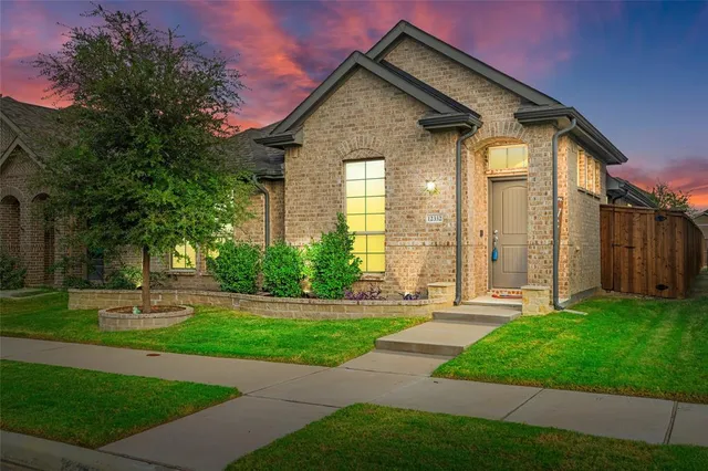 a front view of a house with a yard and trees