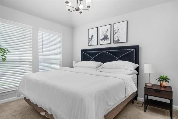 a bedroom with a bed painting on wall and a window