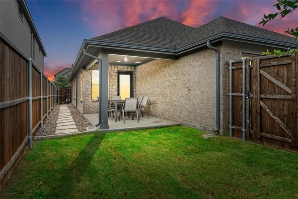a view of a chair and table in backyard of the house