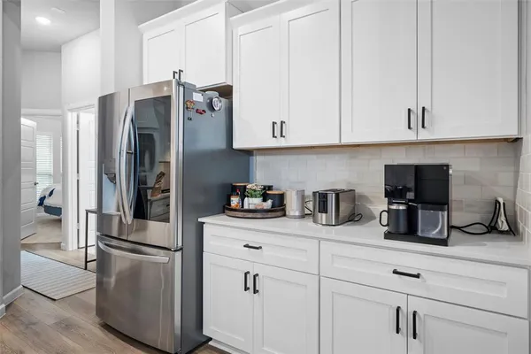 a kitchen with stainless steel appliances white cabinets and a refrigerator
