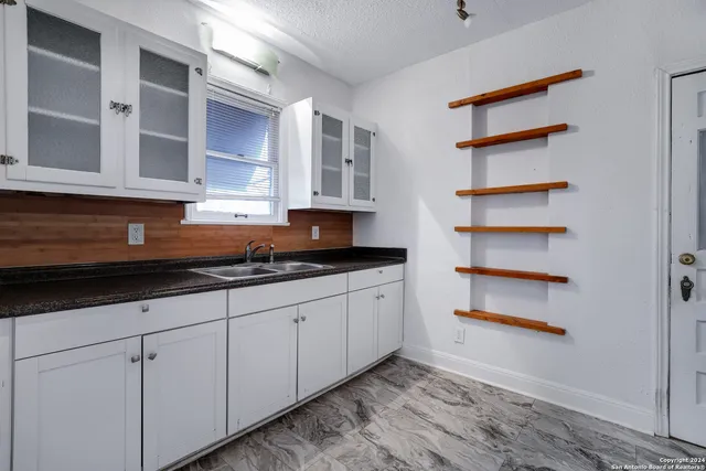 a kitchen with white cabinets and white appliances