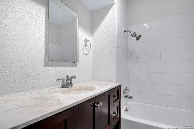 a bathroom with a granite countertop sink a toilet and shower