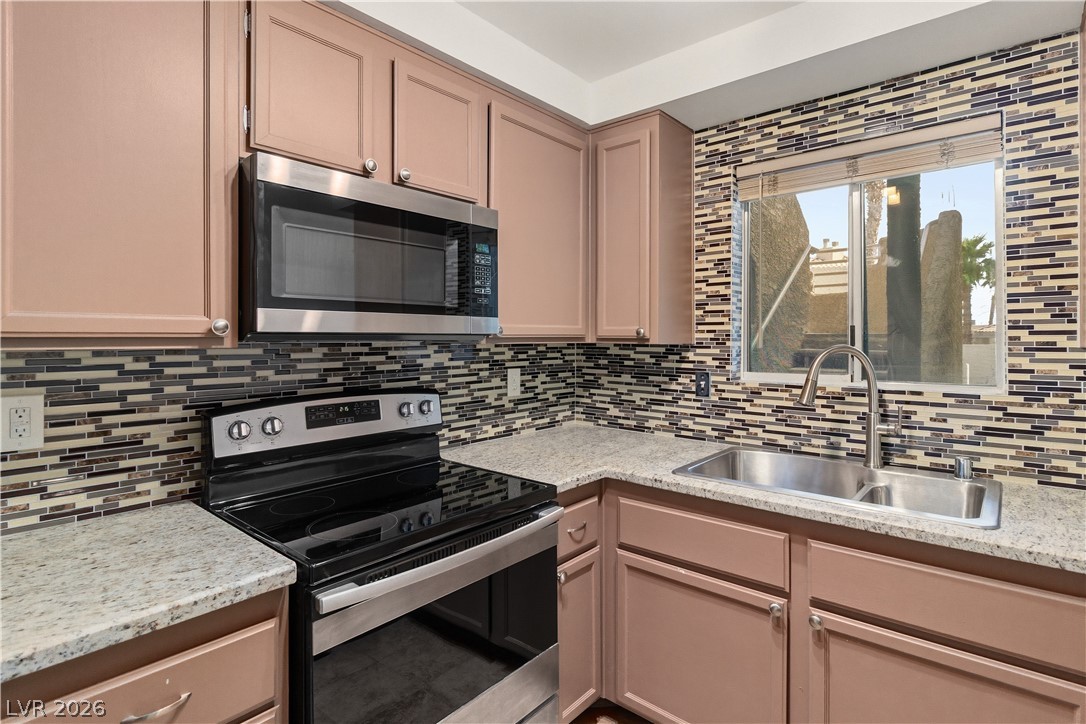 2232 Aspen Mirror Way, Unit 103 Laughlin, NV 89029 - Photo 11 of 50 Kitchen with stainless steel appliances, light stone countertops, and tasteful backsplash