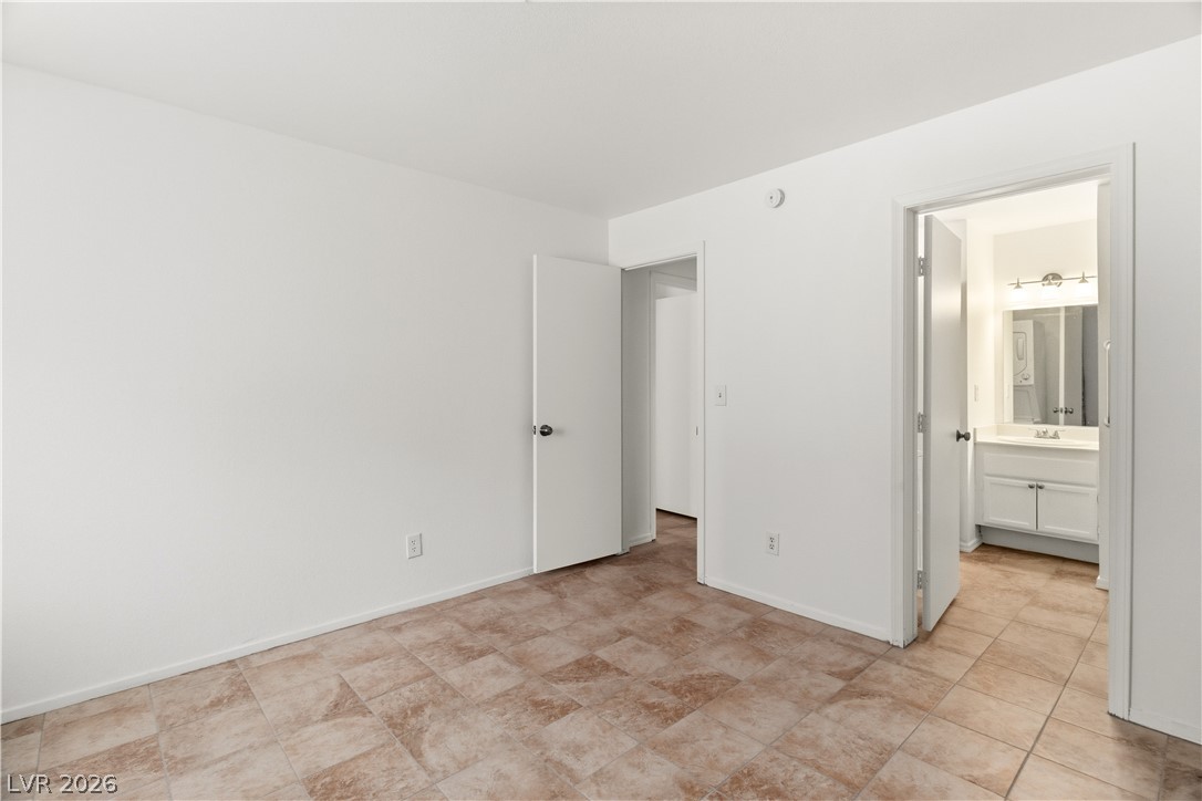 2232 Aspen Mirror Way, Unit 103 Laughlin, NV 89029 - Photo 15 of 50 Unfurnished bedroom with baseboards and ensuite bathroom