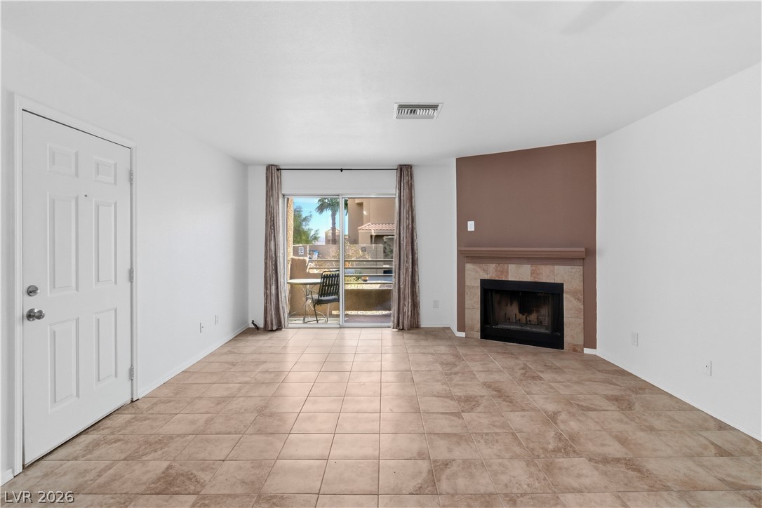 2232 Aspen Mirror Way, Unit 103 Laughlin, NV 89029 - Photo 4 of 50 Unfurnished living room featuring a tiled fireplace