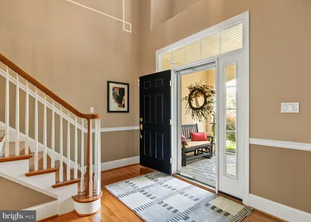 a kitchen with stainless steel appliances granite countertop a refrigerator a sink dishwasher a stove and white cabinets with wooden floor