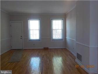 1205 Beech Street Wilmington, DE 19805 - Photo 4 of 13 an empty room with wooden floor and windows
