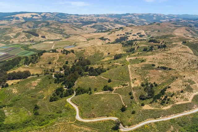 a view of a field with an ocean in the background
