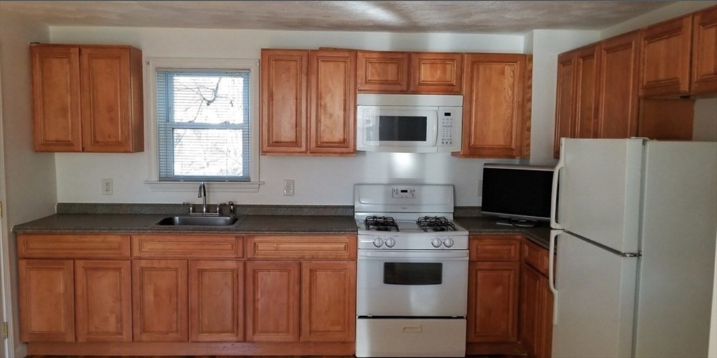 180 Myrtle Street, Unit 1 Lynn, MA 01905 - Photo 3 of 8 a kitchen with stainless steel appliances granite countertop a stove a sink dishwasher and a refrigerator