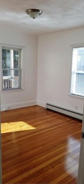 180 Myrtle Street, Unit 1 Lynn, MA 01905 - Photo 4 of 8 a view of empty room with window and wooden floor