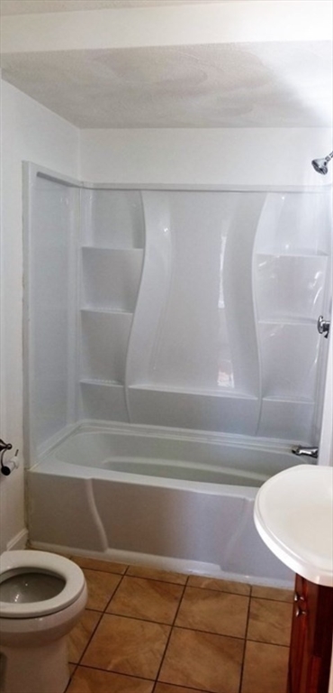180 Myrtle Street, Unit 1 Lynn, MA 01905 - Photo 7 of 8 a bathroom with a toilet and a shower