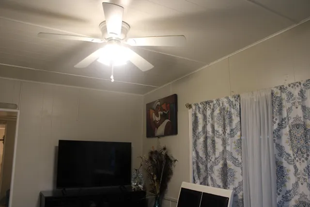 a view of a livingroom with furniture and chandelier fan