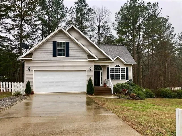 a front view of house with yard and trees around