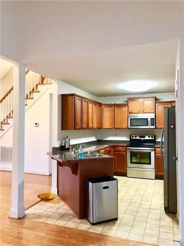 a kitchen with stainless steel appliances granite countertop a stove a sink and a microwave