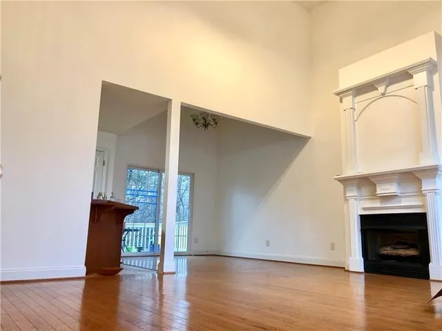 a view of a livingroom with wooden floor and a fireplace
