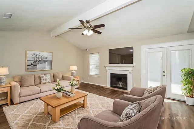 a living room with furniture a fireplace and a flat screen tv