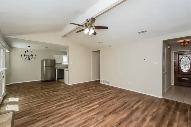 a view of empty room with wooden floor