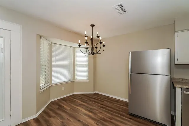 a kitchen with kitchen island a refrigerator a stove and wooden floor