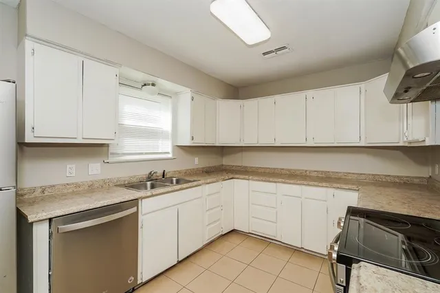 a kitchen with a sink cabinets and window