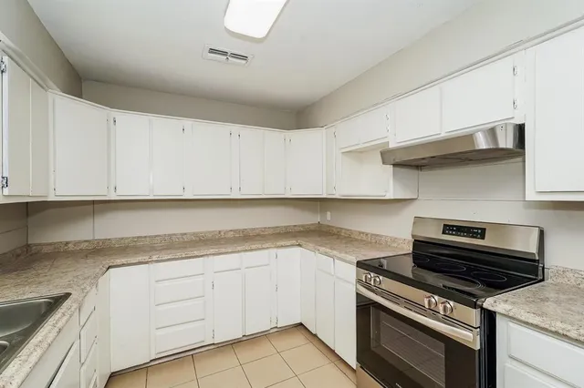 a kitchen with granite countertop a stove and a sink