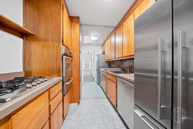 a kitchen with stainless steel appliances granite countertop a refrigerator and a stove