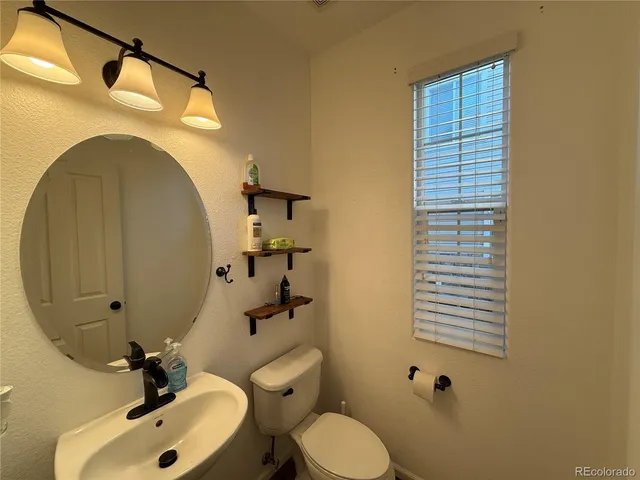a bathroom with a sink toilet and mirror