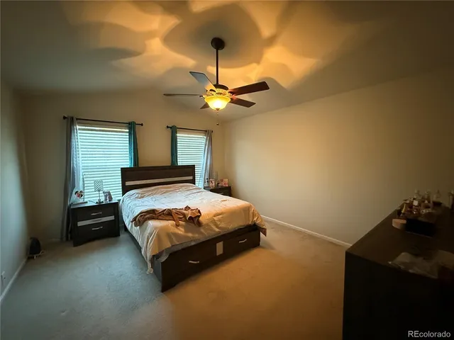 a bedroom with a bed and a ceiling fan