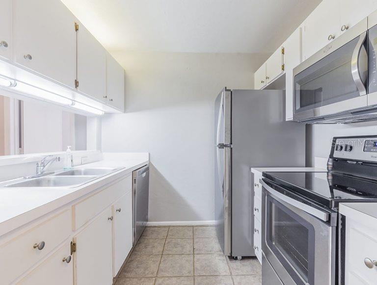 4000 Southwest 23rd Street, Unit 3208 #3 Gainesville, FL 32608 - Photo 5 of 17 a kitchen with stainless steel appliances granite countertop a refrigerator sink and stove