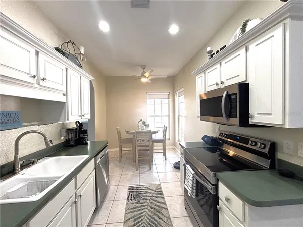 a kitchen with furniture a stove a sink and a microwave