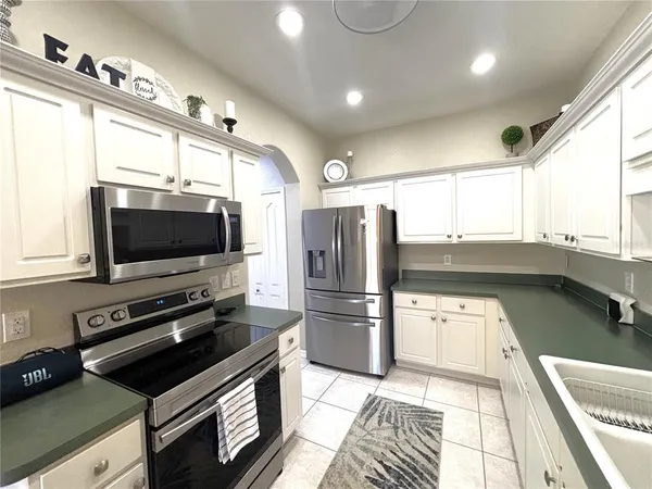 a kitchen with a refrigerator a sink and a stove top oven