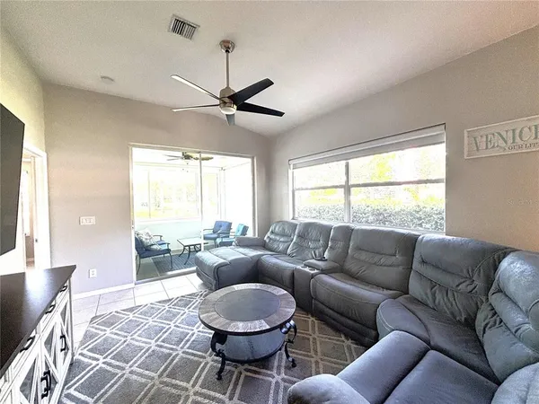 a living room with furniture a ceiling fan and a window