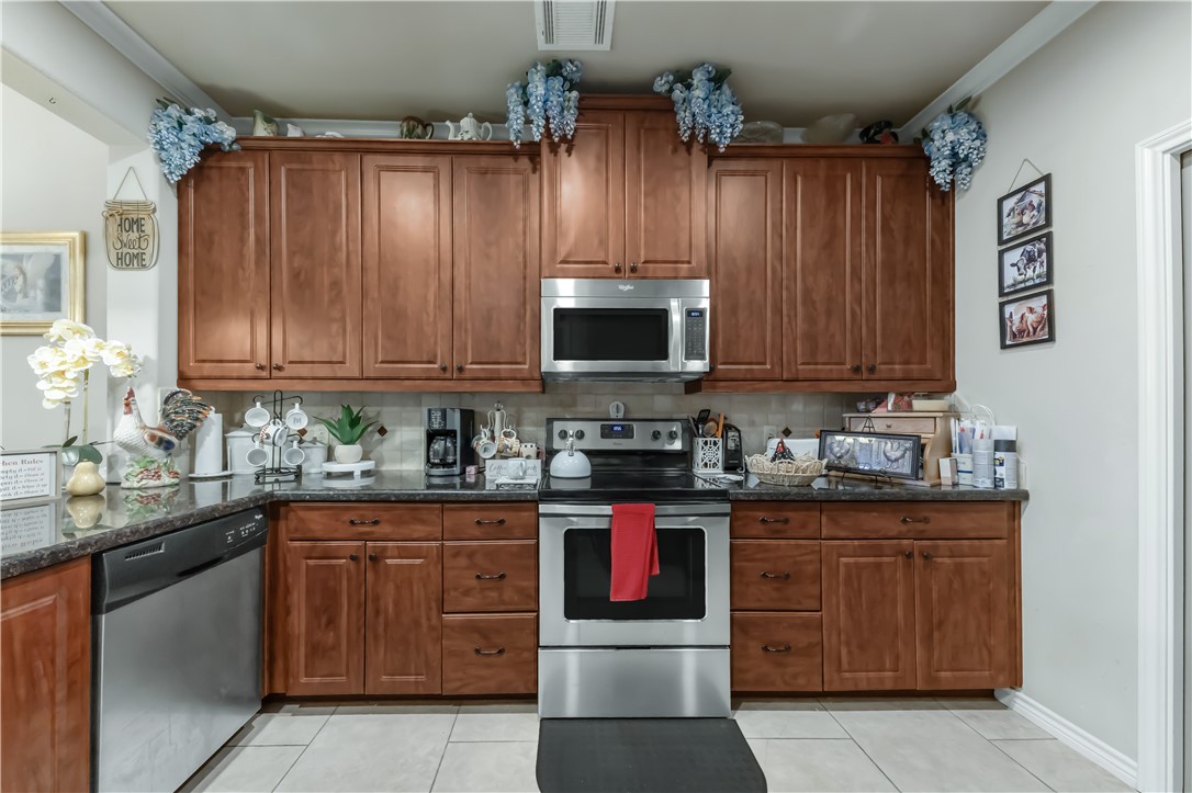 3815 Harvey Road College Station, TX 77845 - Photo 13 of 24 a kitchen with stainless steel appliances granite countertop a stove a sink dishwasher and cabinets with wooden floor