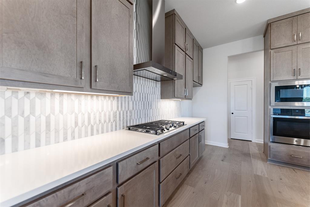 3908 Friendship Court Forney, TX 75126 - Photo 11 of 29 a kitchen with stainless steel appliances granite countertop a stove and a sink
