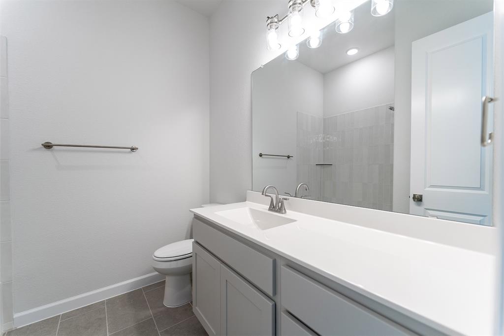 3908 Friendship Court Forney, TX 75126 - Photo 27 of 29 a bathroom with a sink a toilet and a mirror