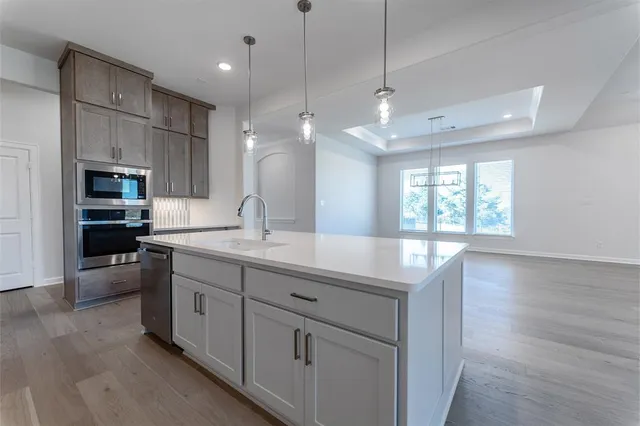 a large kitchen with kitchen island white cabinets and stainless steel appliances