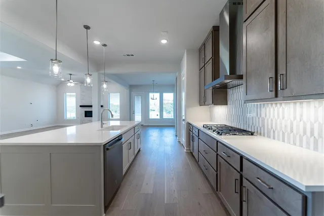 a kitchen with stainless steel appliances granite countertop a sink and stove