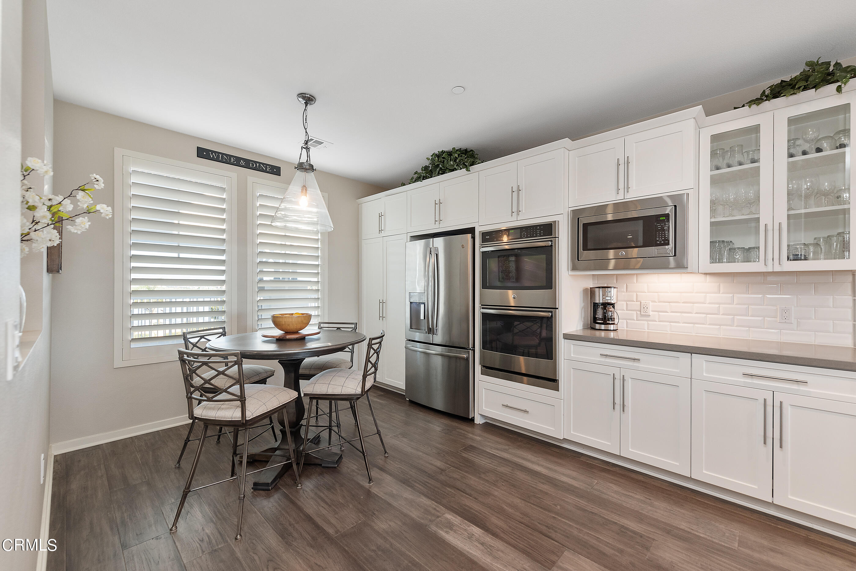 4048 Tradewinds Drive Oxnard, CA 93035 - Photo 17 of 53 a kitchen with stainless steel appliances wooden floor and dining table chairs